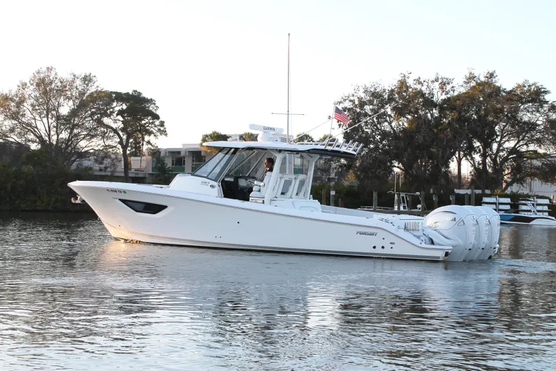  Yacht Photos Pics 2023 Pursuit S 378 Sport boat cruising on a calm river with trees in the background.