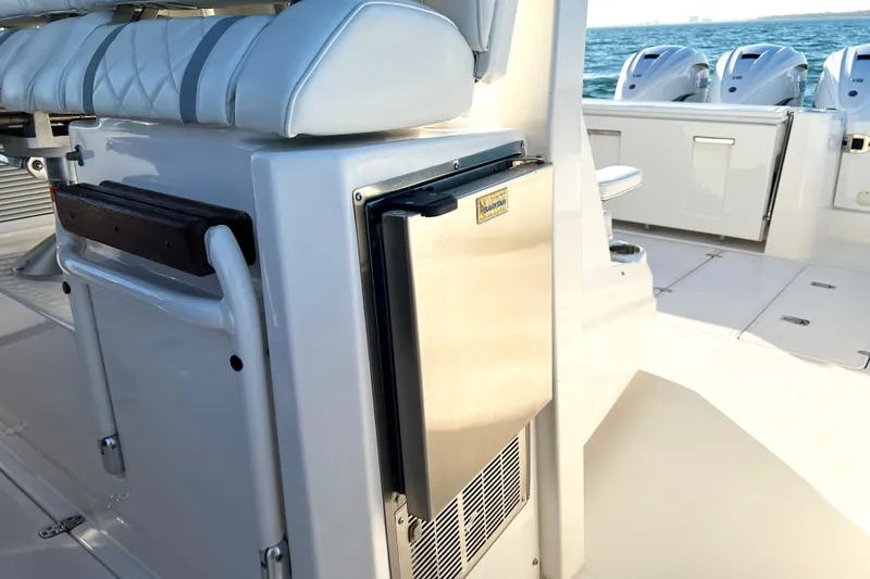  Yacht Photos Pics 2023 Pursuit S 378 Sport boat interior with seating and stainless steel refrigerator.