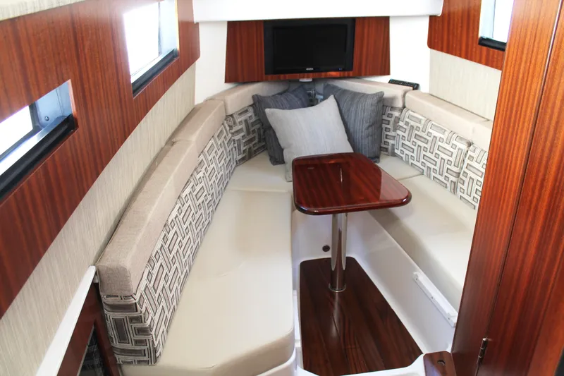  Yacht Photos Pics Luxurious interior of 2023 Pursuit S 378 Sport boat with elegant seating and wooden table.