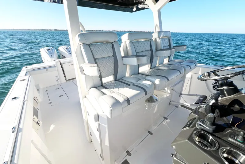  Yacht Photos Pics 2023 Pursuit S 378 Sport boat interior with luxurious seating and modern controls on open water.