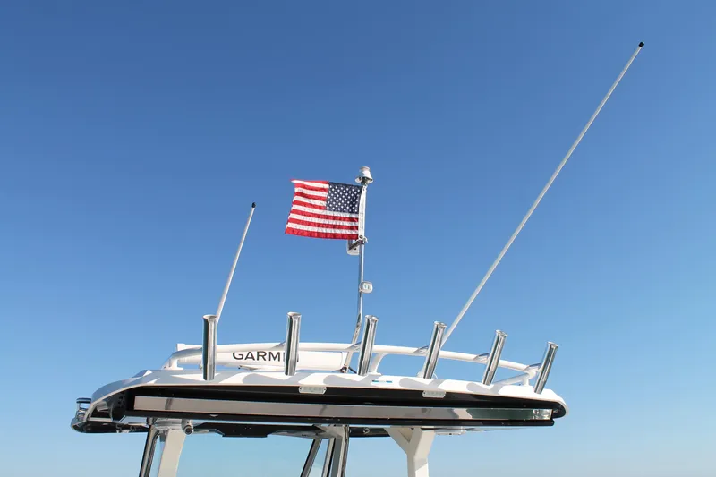  Yacht Photos Pics 2023 Pursuit S 378 Sport boat with American flag against clear blue sky.