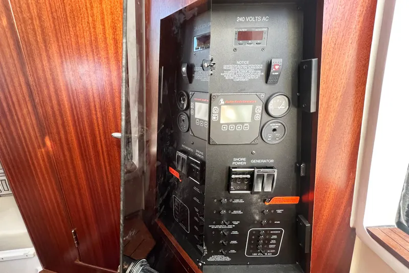  Yacht Photos Pics Electrical control panel on 2023 Pursuit S 378 Sport boat, featuring wood paneling.