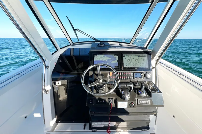  Yacht Photos Pics 2023 Pursuit S 378 Sport boat cockpit with advanced navigation system on open water.
