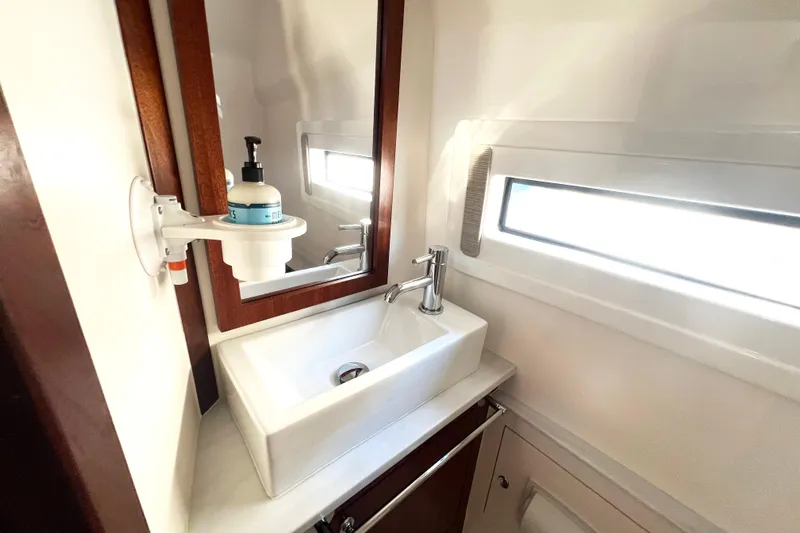  Yacht Photos Pics 2023 Pursuit S 378 Sport boat bathroom with modern sink and window.