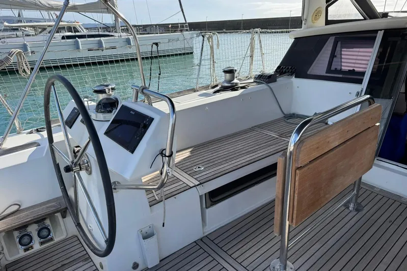  Yacht Photos Pics 2017 Beneteau Sense 51 yacht cockpit with steering wheel and wooden seating.