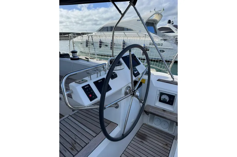  Yacht Photos Pics Steering wheel of 2017 Beneteau Sense 51 yacht, docked with other boats in background.