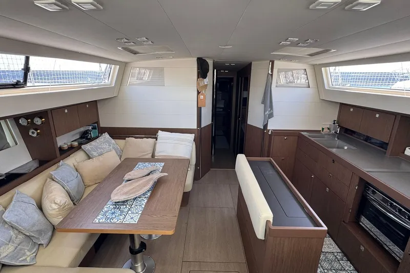  Yacht Photos Pics 2017 Beneteau Sense 51 yacht interior with modern kitchen and cozy seating area.