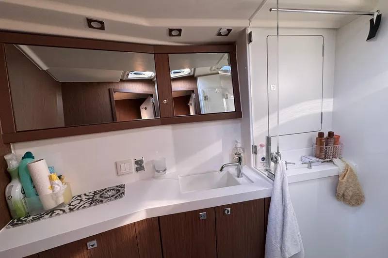  Yacht Photos Pics Luxurious bathroom interior of 2017 Beneteau Sense 51 yacht with modern fixtures and wooden cabinetry.