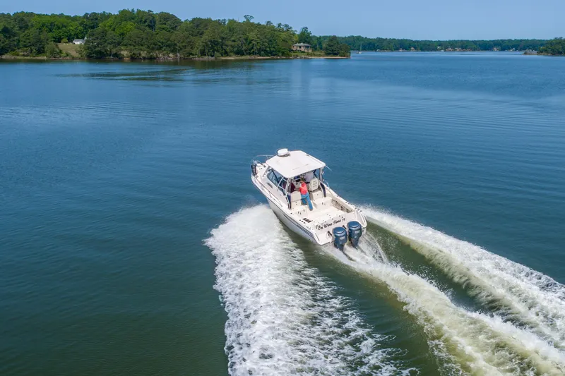 On Wine Time Yacht Photos Pics 2009 Grady-White Chesapeake 290 cruising on a serene lake with lush green shoreline.