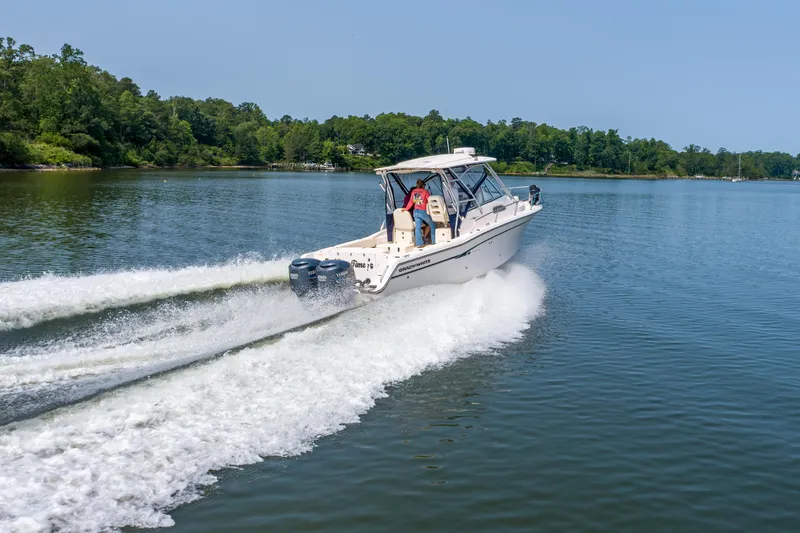 On Wine Time Yacht Photos Pics 2009 Grady-White Chesapeake 290 cruising on a serene lake with lush green shoreline.