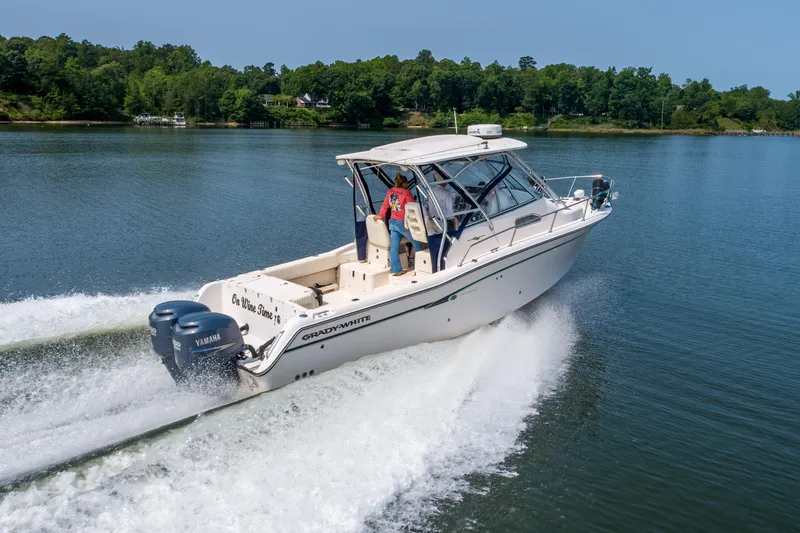 On Wine Time Yacht Photos Pics 2009 Grady-White Chesapeake 290 boat cruising on a serene lake with lush green shoreline.