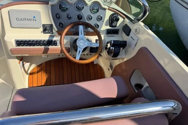 Snippy Yacht Photos Pics 2019 Chris-Craft Launch 30 cockpit with Garmin navigation, wooden steering wheel, and control panel.