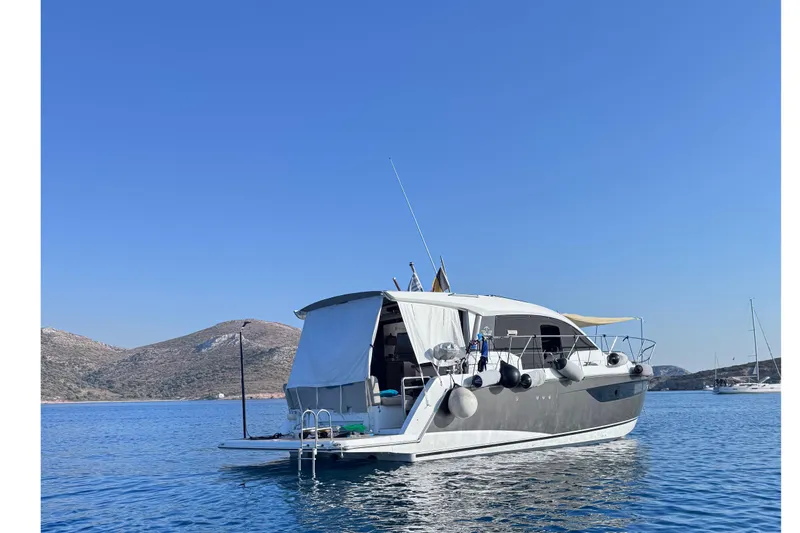  Yacht Photos Pics 2016 Sealine C330 yacht anchored in serene blue waters with scenic hills.