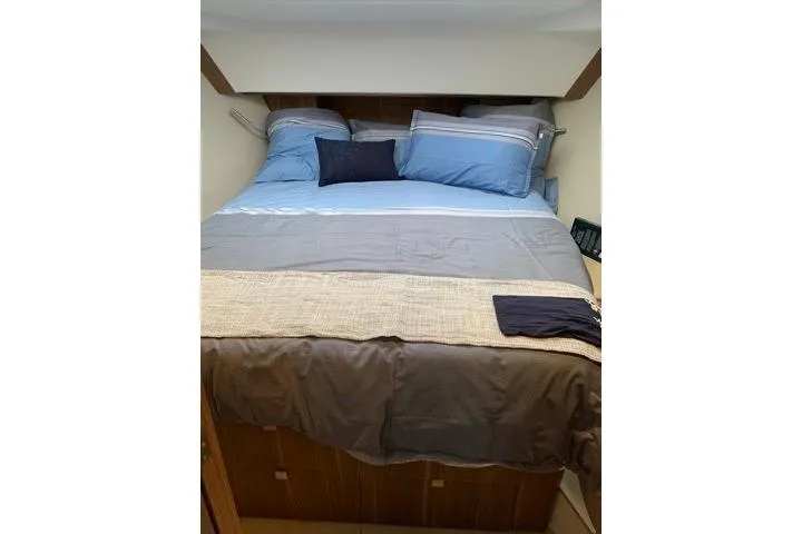  Yacht Photos Pics Cozy bedroom interior of 2016 Sealine C330 yacht with blue bedding and pillows.