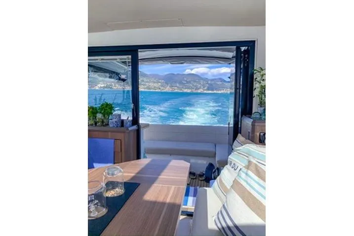  Yacht Photos Pics Interior view of 2016 Sealine C330 yacht with ocean and mountain backdrop.