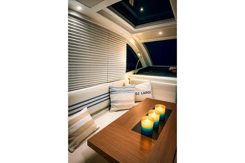  Yacht Photos Pics Interior of 2016 Sealine C330 yacht with cozy seating and candles on a wooden table.