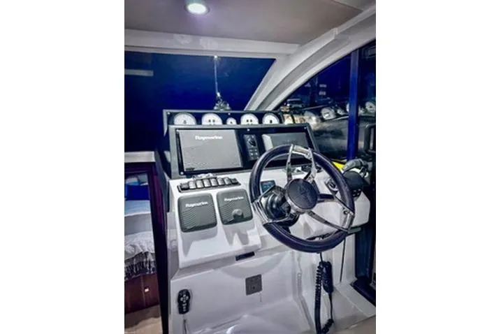  Yacht Photos Pics Control panel of 2016 Sealine C330 boat with steering wheel and navigation equipment.
