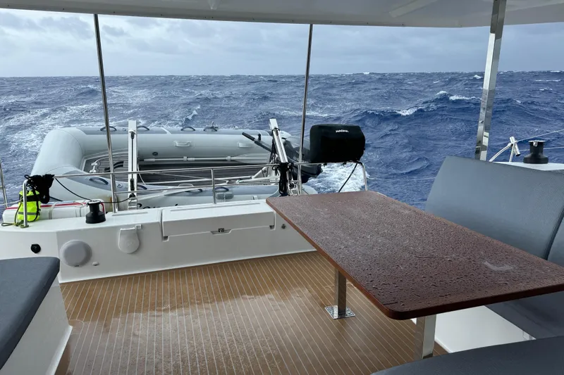 Khonsu Yacht Photos Pics 2023 Fountaine Pajot Isla catamaran deck with ocean view and inflatable boat.