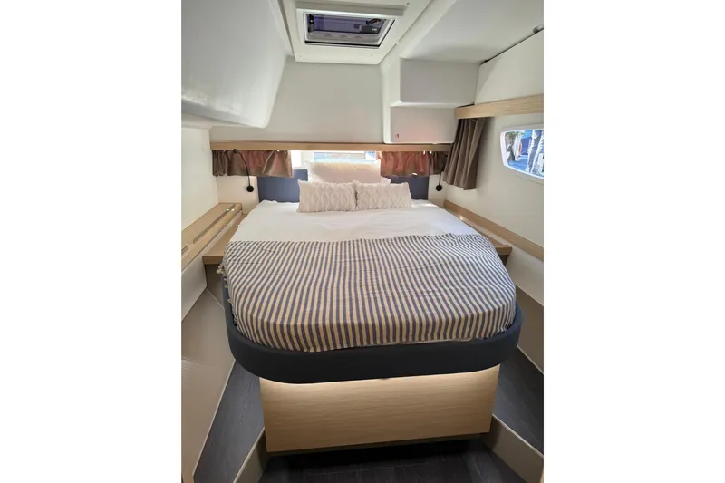 Khonsu Yacht Photos Pics Luxurious bedroom interior of 2023 Fountaine Pajot Isla catamaran with cozy bed and modern design.