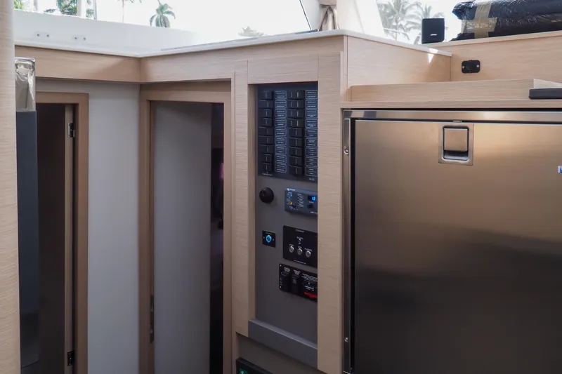 Khonsu Yacht Photos Pics 2023 Fountaine Pajot Isla yacht interior with control panel and stainless steel fridge.