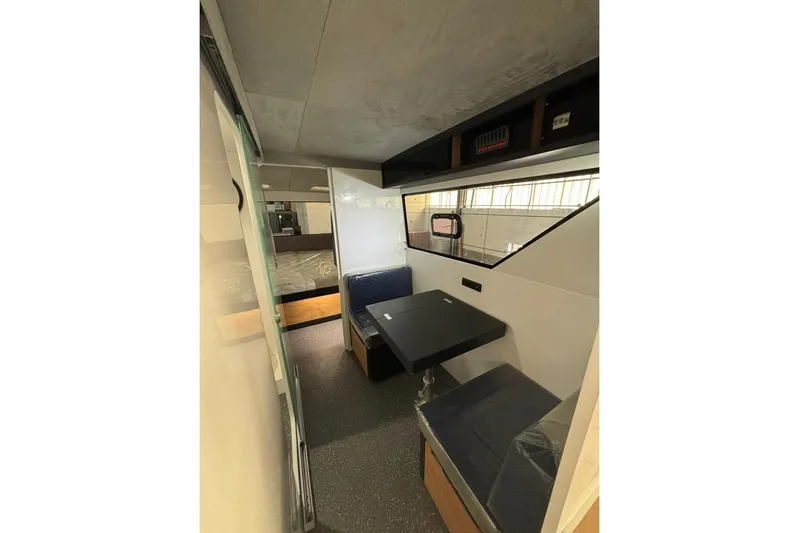 Sol Provider Yacht Photos Pics Interior of 2023 Hop Yacht 30, featuring a compact dining area with blue seating.