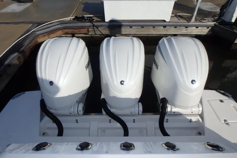  Yacht Photos Pics Triple Yamaha outboard engines on a 2022 Regal 38 SAV boat at a dock.