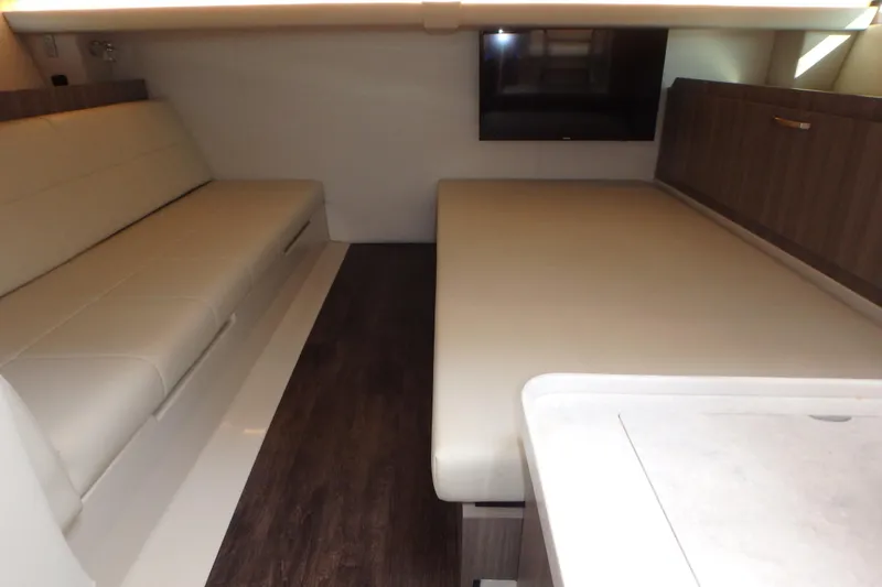  Yacht Photos Pics 2022 Regal 38 SAV interior with modern seating, wood flooring, and a mounted TV.