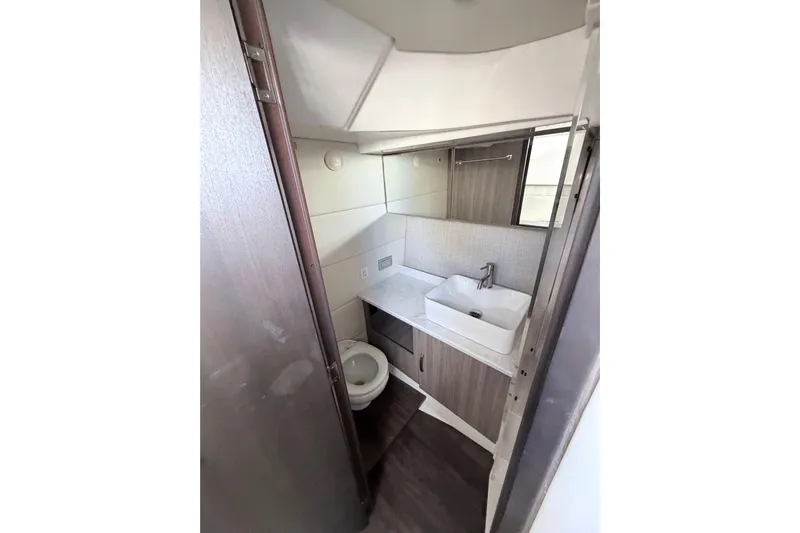  Yacht Photos Pics Compact bathroom in 2022 Regal 38 SAV yacht with modern sink and toilet.