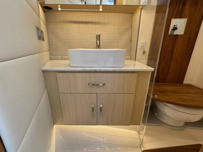 36 Xo Yacht Photos Pics Modern bathroom interior of 2026 Regal 36 XO yacht, featuring sleek sink and wooden cabinetry.