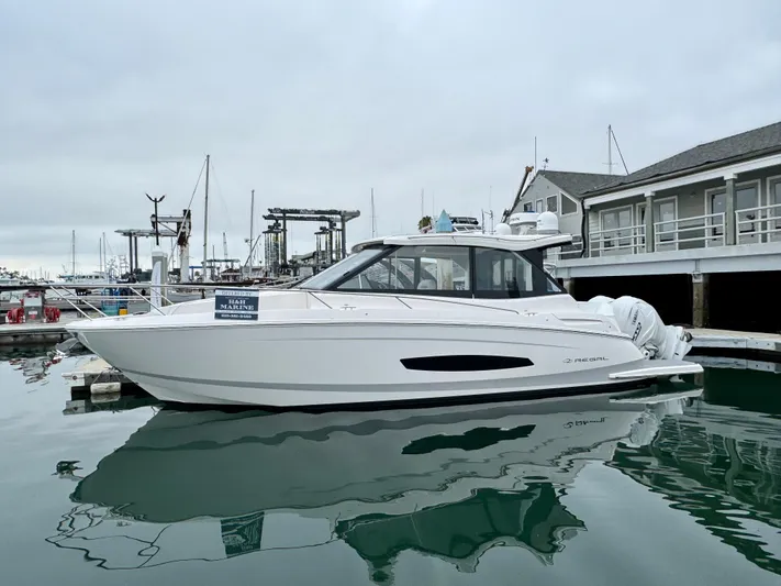 36 Xo Yacht Photos Pics 2026 Regal 36 XO yacht docked at marina, overcast sky, calm water reflection.