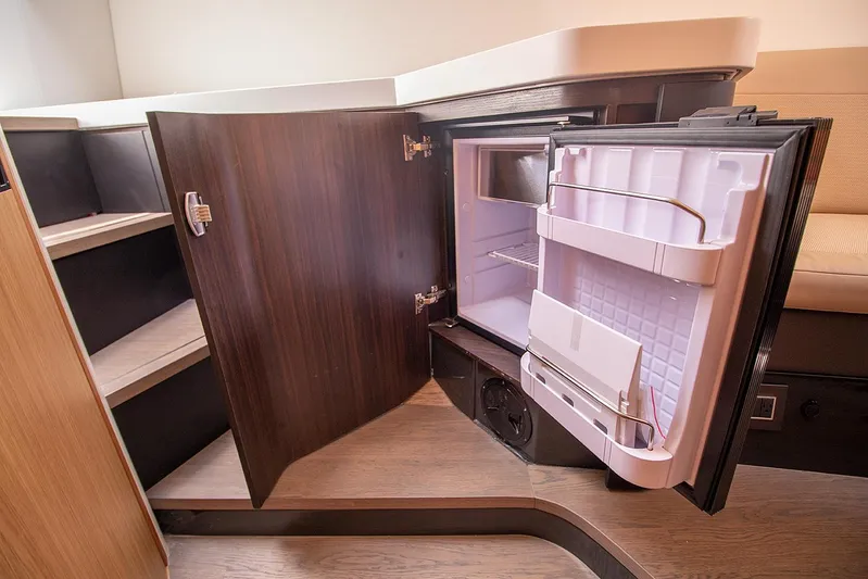  Yacht Photos Pics Fairline F Line 33 2021 yacht interior with open mini fridge and storage shelves.