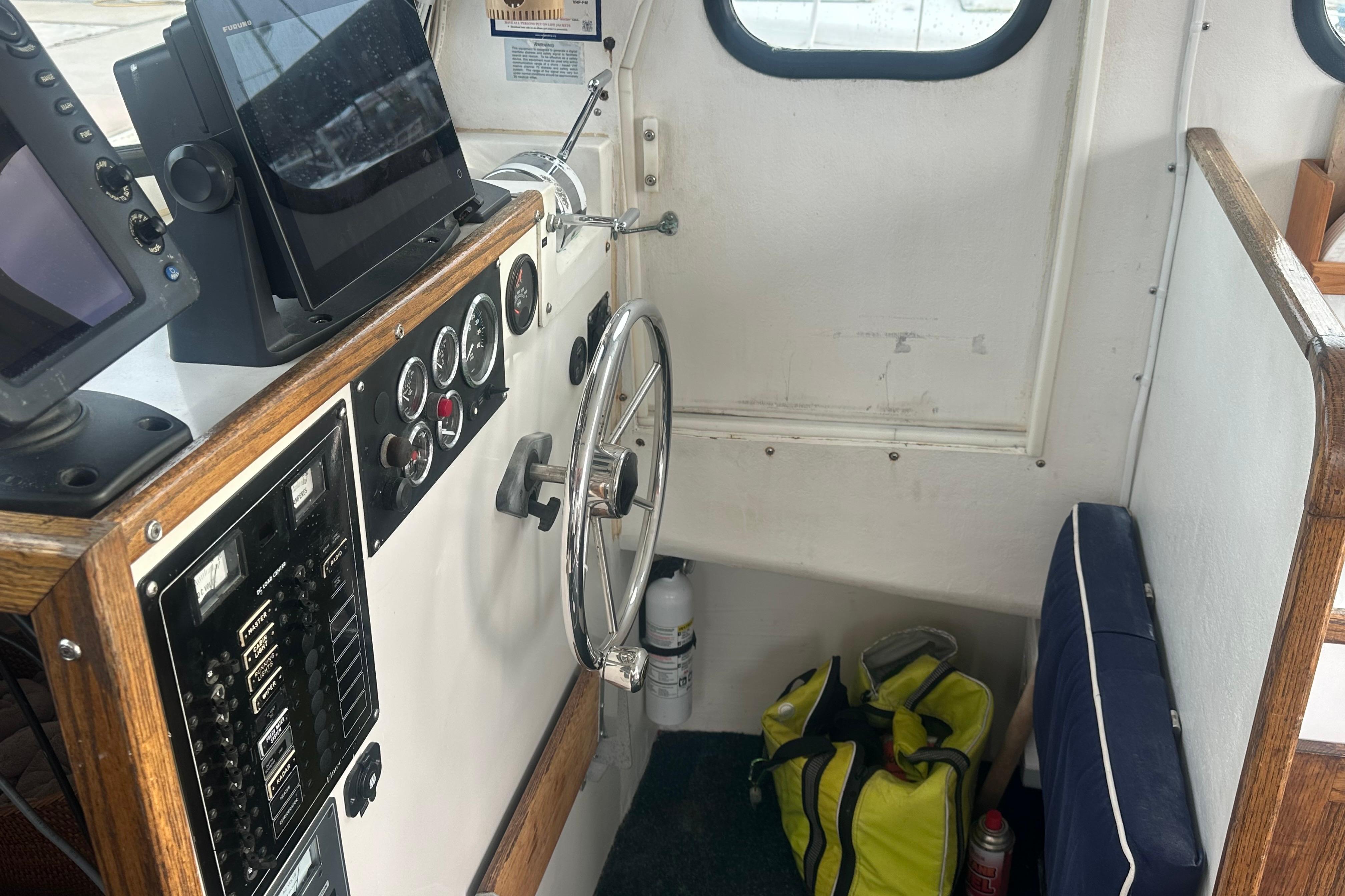 Interior of 1999 Samson East Coast Lobster boat with steering wheel and navigation equipment.