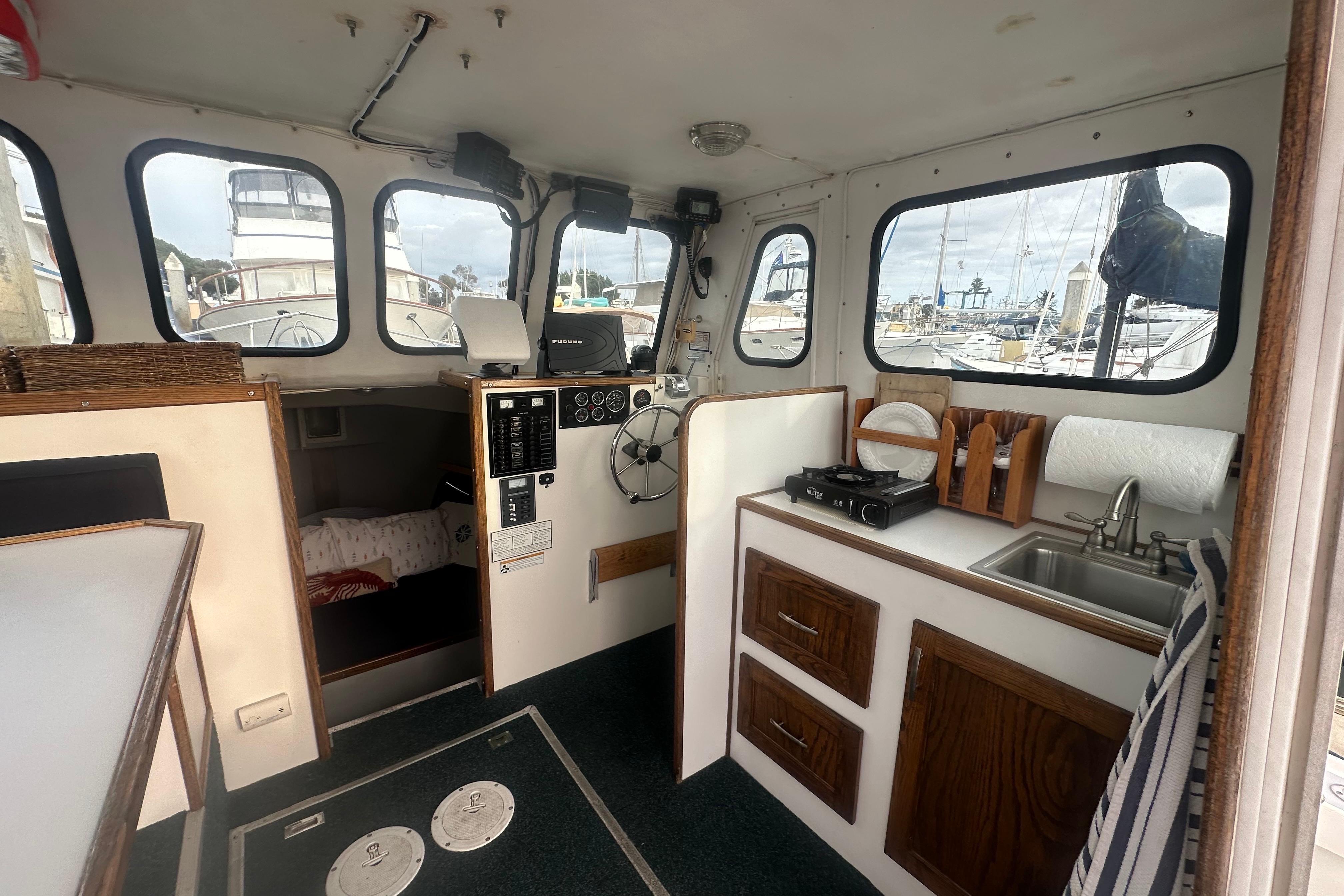 Interior of 1999 Samson East Coast Lobster boat with kitchenette and helm, docked at marina.