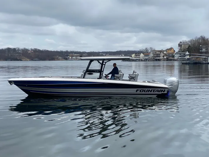  Yacht Photos Pics 2023 Fountain 34 SC boat on calm lake with overcast sky.