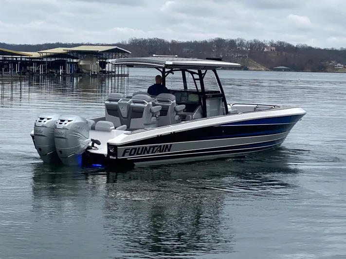  Yacht Photos Pics 2023 Fountain 34 SC boat on a calm lake with overcast skies.