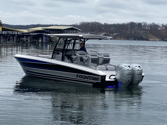  Yacht Photos Pics 2023 Fountain 34 SC boat on a calm lake with overcast skies.