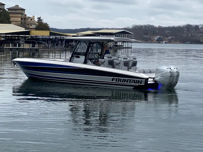  Yacht Photos Pics 2023 Fountain 34 SC boat on a calm lake near docks.
