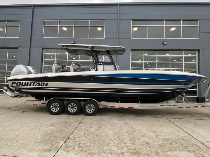  Yacht Photos Pics 2023 Fountain 34 SC boat on trailer, sleek design, parked outside a modern building.