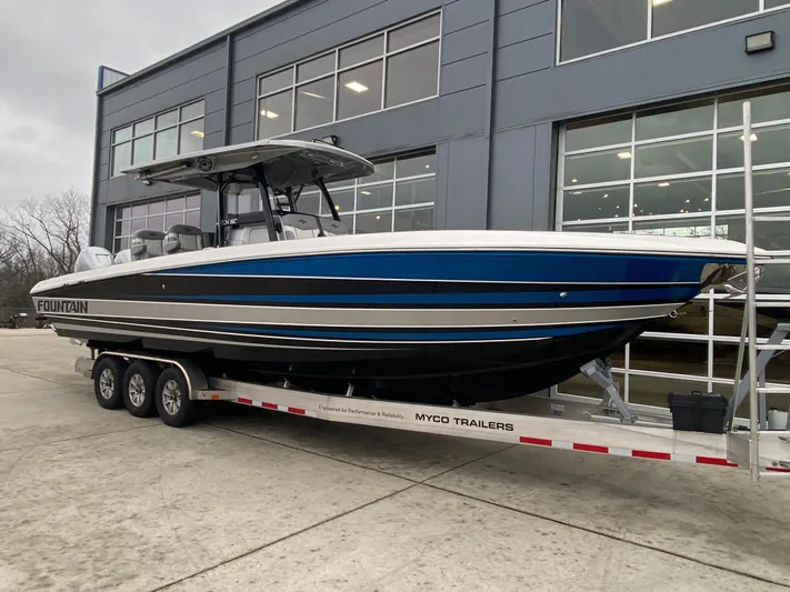  Yacht Photos Pics 2023 Fountain 34 SC boat on trailer outside modern building.