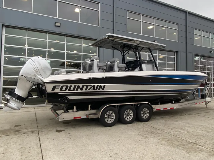  Yacht Photos Pics 2023 Fountain 34 SC boat on trailer outside a modern building.