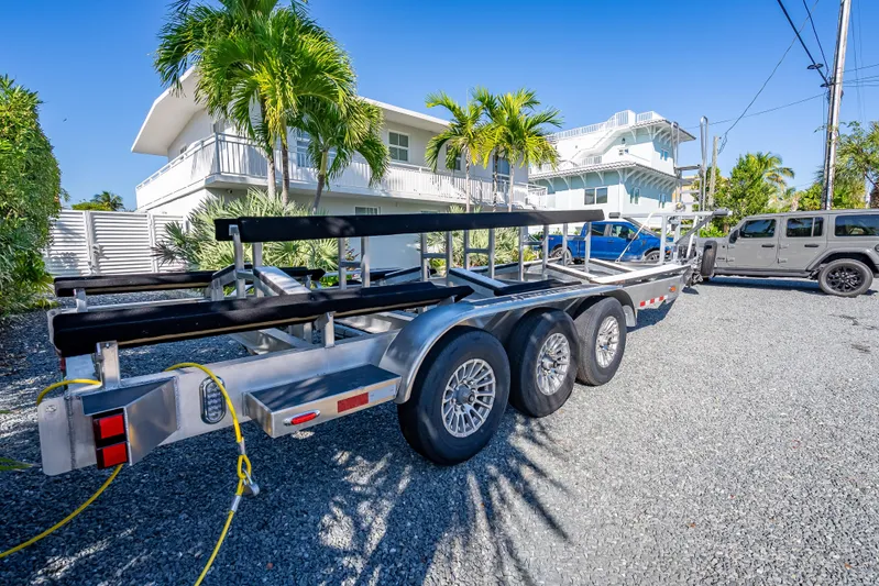  Yacht Photos Pics Trailer for Freeman 35 boat, 2026 model, parked on gravel near tropical house.