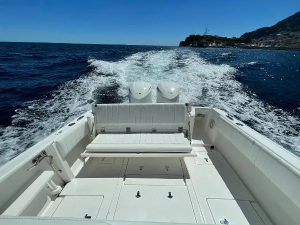  Yacht Photos Pics 2013 Intrepid 327 OPEN boat cruising on open water, rear view.