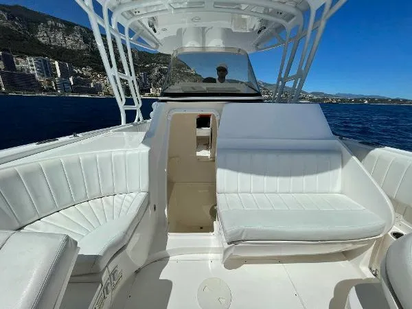  Yacht Photos Pics 2013 Intrepid 327 OPEN boat interior with white seating, ocean view, and coastal cityscape.