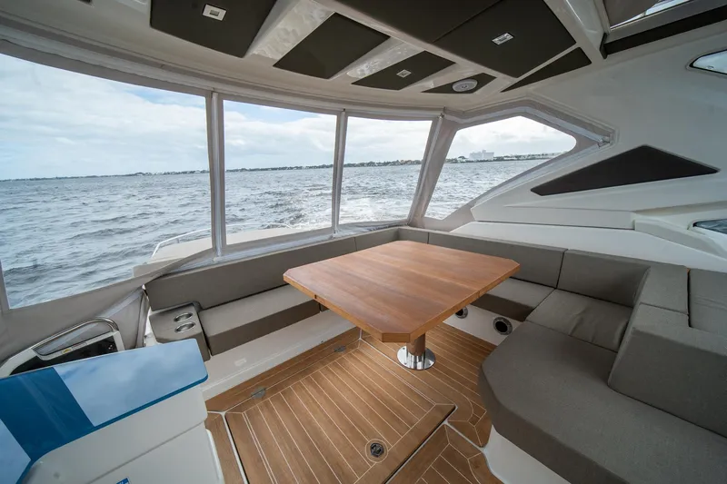 Dominus Yacht Photos Pics Interior of 2012 Cranchi 56 yacht with panoramic windows and wooden table.