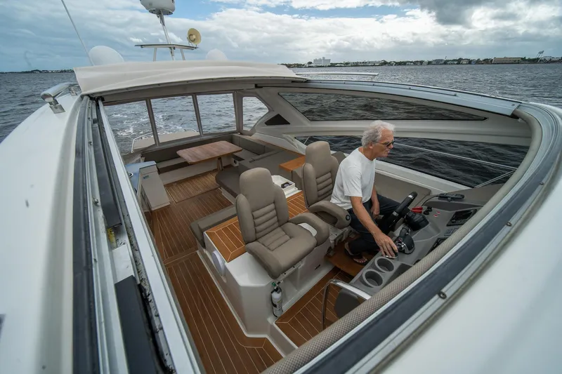 Dominus Yacht Photos Pics 2012 Cranchi 56 yacht with a person at the helm, cruising on open water.