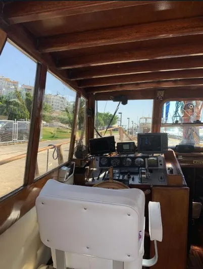  Yacht Photos Pics Interior view of a 1981 Custom Traditional Motor Sailer, showcasing the wooden helm and navigation equipment.