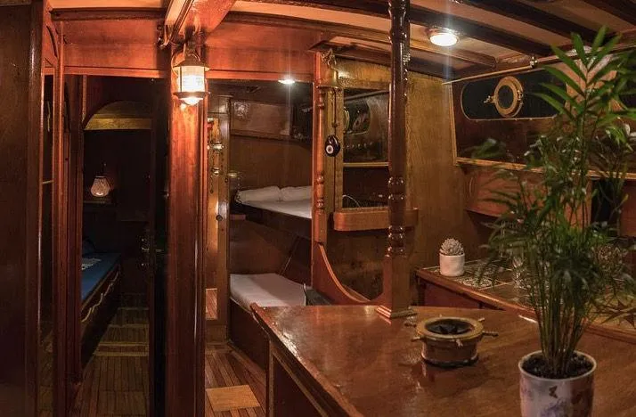  Yacht Photos Pics Interior of a 1981 traditional motor sailer, featuring wooden decor and cozy sleeping quarters.