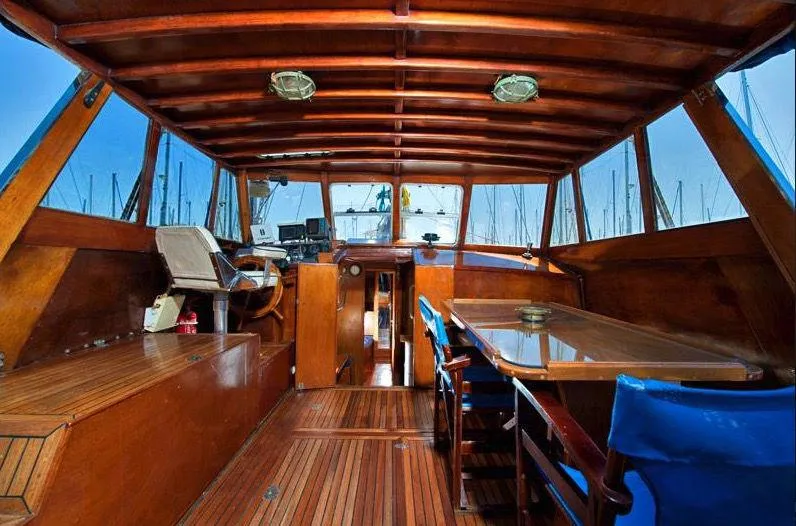  Yacht Photos Pics Interior of a 1981 Custom Traditional Motor Sailer, featuring wooden design and seating area.