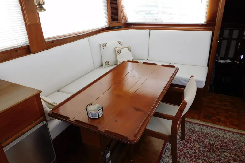 Susan Gail Yacht Photos Pics Interior of 1986 Grand Banks 46 Classic yacht with wooden table and white seating.