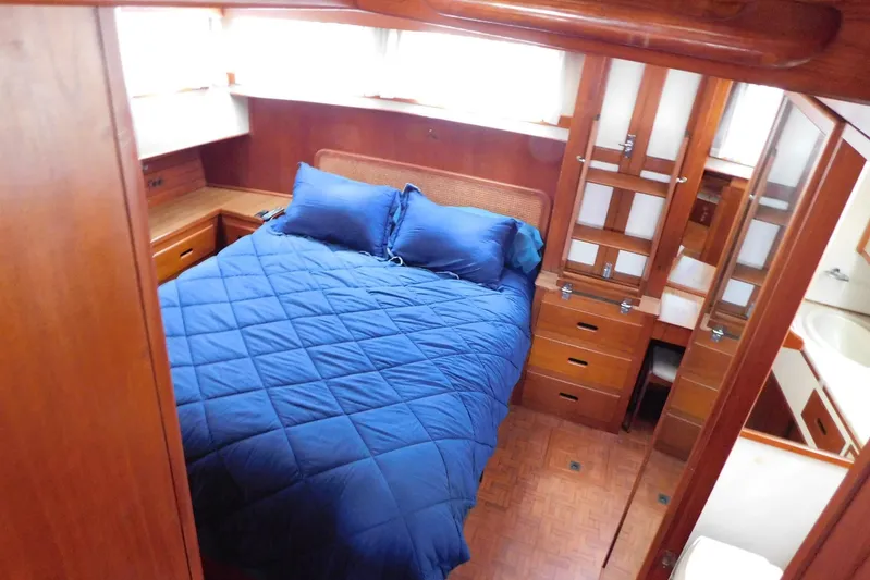 Susan Gail Yacht Photos Pics Cozy bedroom in 1986 Grand Banks 46 Classic yacht with blue bedding and wooden cabinetry.